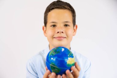 Closeup portrait of school boy holding a world globe isolated over white background