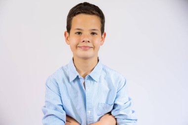 Smiling little boy with arms folded isolated over white background