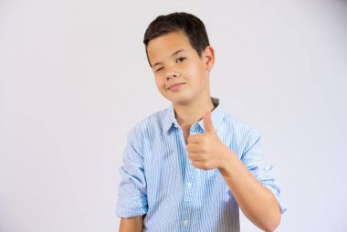 Cute boy in casual shirt showing thumb up isolated over white background.