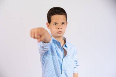 Little boy with angry face pointing to camera isolated over white background