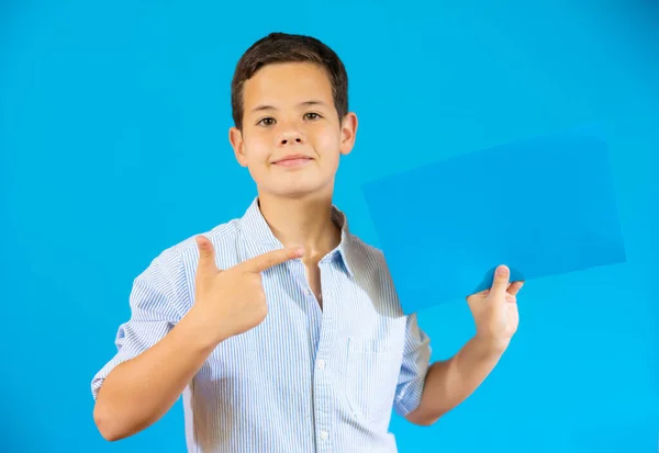 Cute Boy Showing Blue Blank Paper Isolated Blue Background — Stock Fotó