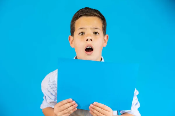 Excited Boy Showing Blue Blank Paper Isolated Blue Background — Zdjęcie stockowe