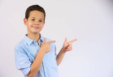 A handsome boy is pointing to the side over white background