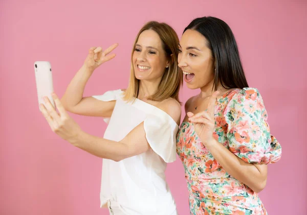 Dos Amigos Usando Teléfono Móvil Sobre Fondo Rosa — Foto de Stock