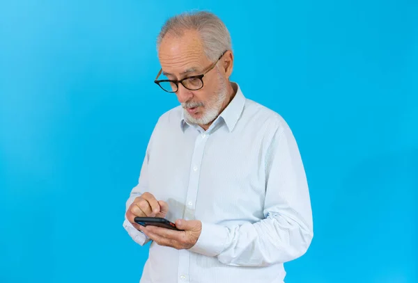 Portrét Šťastný Evropský Starší Muž Telefonem Přes Modré Pozadí — Stock fotografie