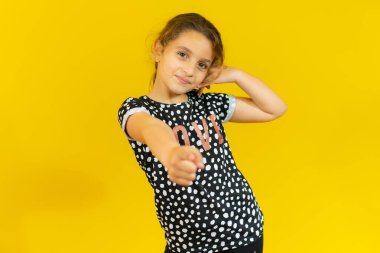 Pembe arka planda gülümseyen İspanyol bir çocuk telefonla el ve parmaklarıyla jest yapıyor telefonda konuşuyor gibi. İletişim kavramları.