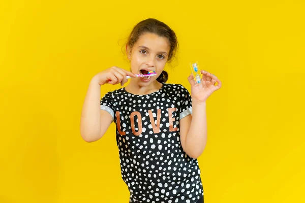 Cute Little Girl Szczotkowanie Zębów Izolowane Żółtym Tle — Zdjęcie stockowe