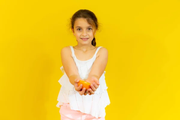 Cute Uroczy Dziewczynka Białym Shirt Gospodarstwa Pół Pomarańczowy Żółtym Tle — Zdjęcie stockowe