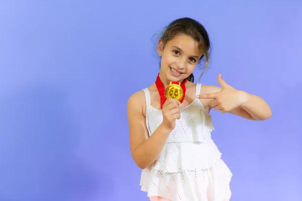Küçük Kız Altın Madalyasını Mor Arka Planda Gösteriyor — Stok fotoğraf