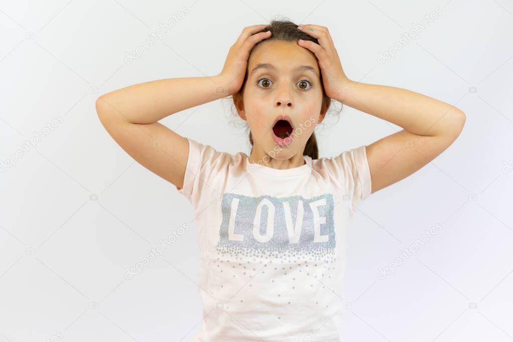 Excited little girl in casual clothes isolated over white background
