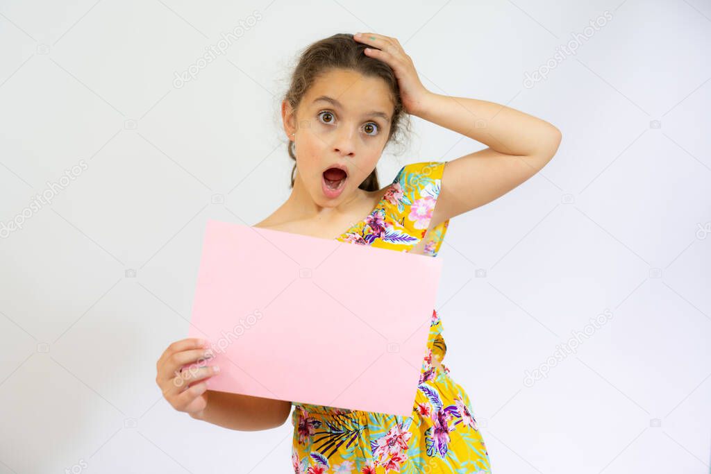 Smiling little girl holding empty pink board isolated over white background.