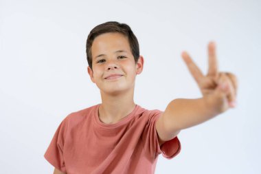 Beyaz arka planda zafer işareti gösteren küçük bir çocuğun portresi