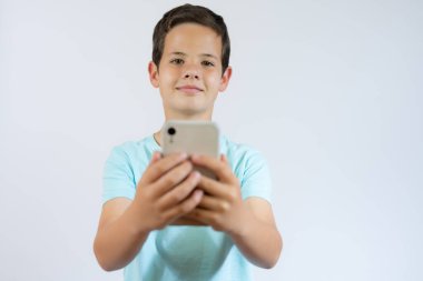 Sarı arka planda izole edilmiş cep telefonu kullanan sevimli çocuk..