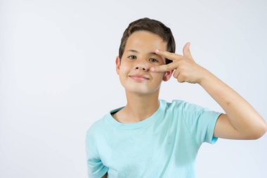 Beyaz arka planda zafer işareti gösteren küçük bir çocuğun portresi