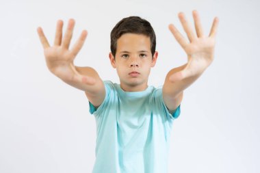 Kes jesti. Reddetme işareti. Reddedilmeyi teklif et. Hayır, teşekkürler. Mavi tişörtlü, avucu açık bir şekilde mavi fotokopi çekilen arka plandaki kameraya bakan sinirli gencin portresi..