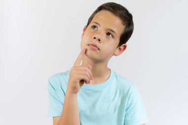 Beyaz arka planda izole edilmiş neşeli çocuk portresi. 10 yaşında bir çocuk işaret ediyor. Çocuk parmağıyla yukarı doğru işaret ediyor. Neşeli çocuk bir şeyler gösteriyor.