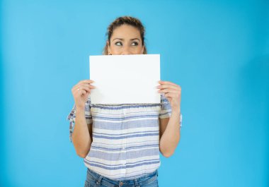 Mavi arka planda beyaz pankart taşıyan komik kadın..