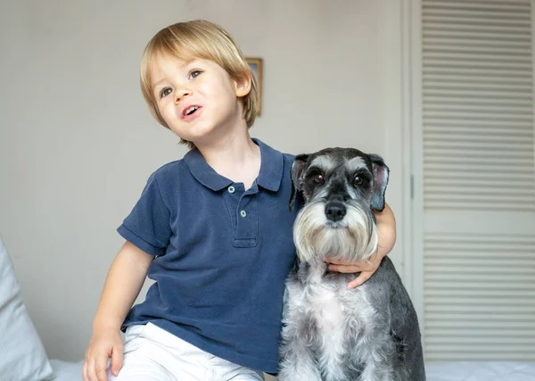 かわいい赤ちゃんが犬と一緒にベッドに座っている 動物愛護 — ストック写真