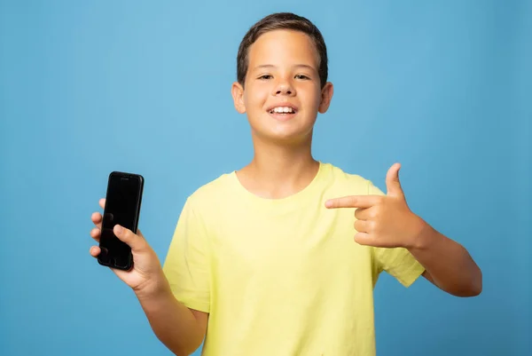 Pojke Som Visar Telefon Isolerad Blå Bakgrund — Stockfoto