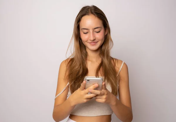 Retrato Una Joven Mujer Casual Sonriente Mirando Teléfono Móvil Aislado —  Fotos de Stock