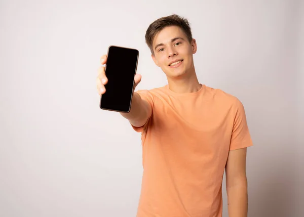 Söt Ung Man Som Visar Mobiltelefon Vit Bakgrund — Stockfoto