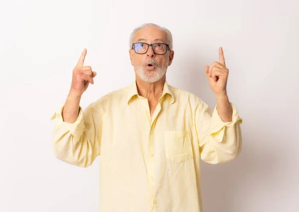Senior Surpreendido Homem Apontando Dedos Para Cima Sobre Fundo Branco — Fotografia de Stock
