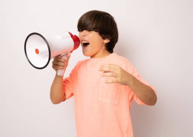 Beyaz arka planda izole edilmiş bir megafonla bağıran genç bir çocuğun portresi