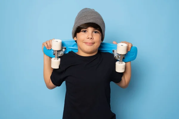 Giovane Ragazzo Sorridente Possesso Skateboard Isolato Sfondo Blu — Foto Stock