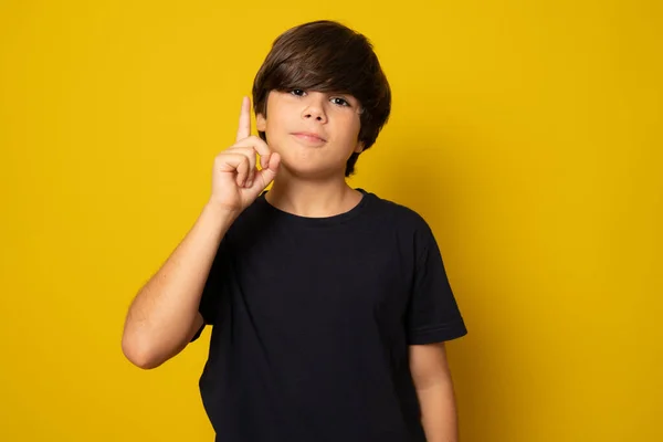 Χαριτωμένο Παιδί Δείχνει Δάχτυλό Του Επάνω Απομονωμένο Κίτρινο Φόντο — Φωτογραφία Αρχείου