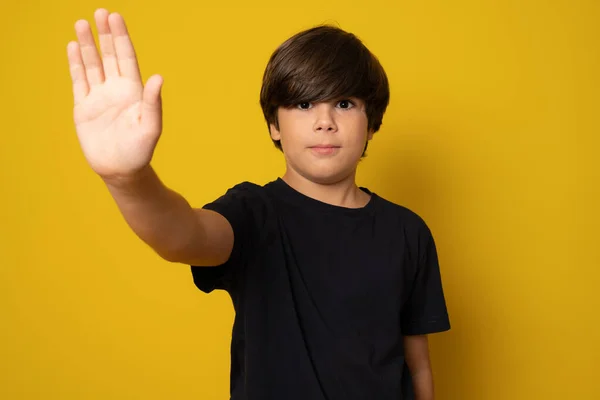 Bambino Guarda Telecamera Segnale Stop Con Mano Sfondo Giallo — Foto Stock