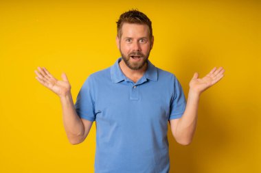 Yüzünde sürpriz ifade olan izole edilmiş sarı bir arka plan.