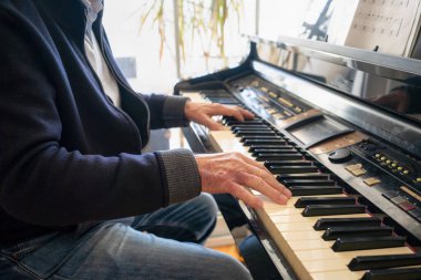 Evde piyano çalan kıdemli adam..