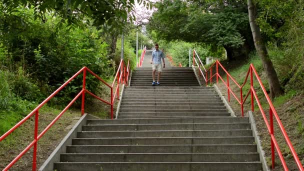 Homem desce as escadas - natureza - tiro de baixo — Vídeo de Stock