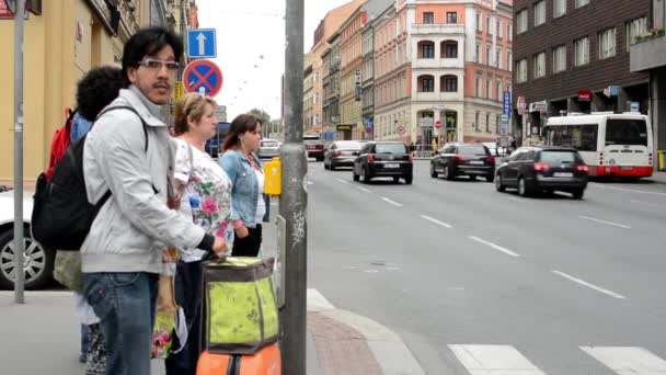 Pedestrians waiting at traffic lights - busy urban street with cars in the city — Stock Video