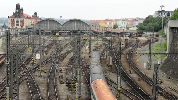 El tren llega a la estación principal de tren - ciudad (edificios) con coches en el fondo — Vídeo de stock