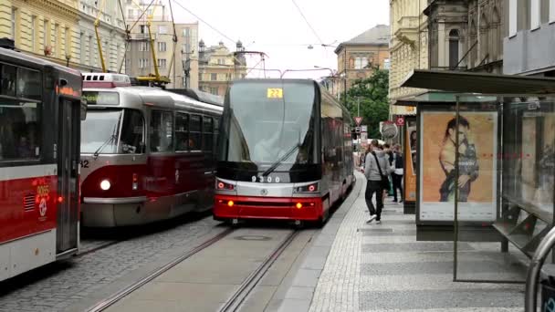 Commuter mensen - mensen krijgen en uitstappen uit tram - stad (gebouwen) met passerende auto's in achtergrond - reclame billboard — Stockvideo