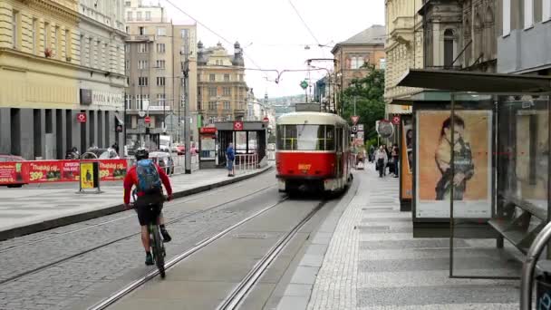 Työmatkalaiset - ihmiset nousevat raitiovaunusta - kaupunki (rakennukset) ohikulkevilla autoilla taustalla - mainostaulu - timelapse — kuvapankkivideo