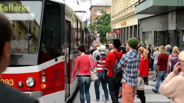 Podmiejskich ludzi - ludzi się i wysiąść z tramwaju - miasto (budynki) z przejeżdżających samochodów w tle — Wideo stockowe