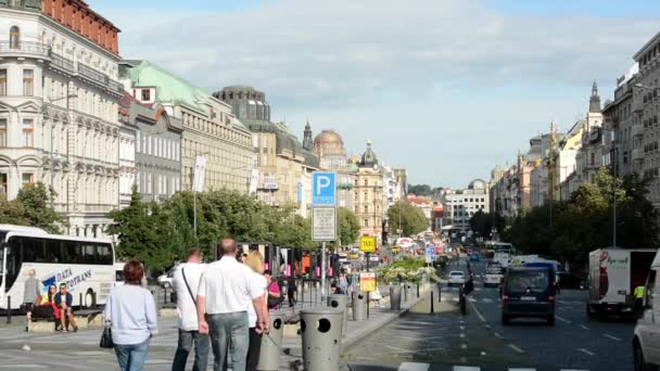 Wenceslas Square with people and passing cars - buildings and nature(trees and bushes) - blue sky — Stock Video