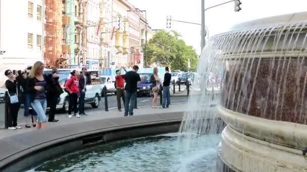Fontana con le persone - passando auto con edifici sullo sfondo - fotografare le persone — Video Stock