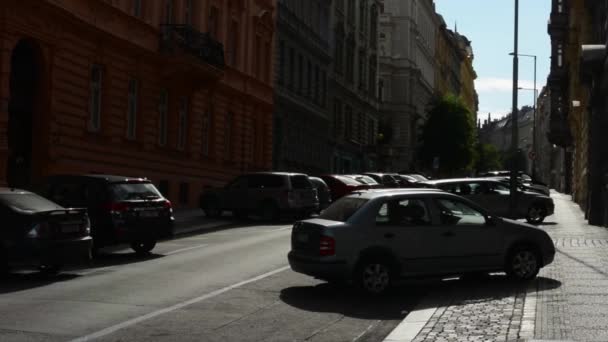 Міська вулиця з припаркованими машинами - блакитне небо - сонце ( сонячні промені ) — стокове відео