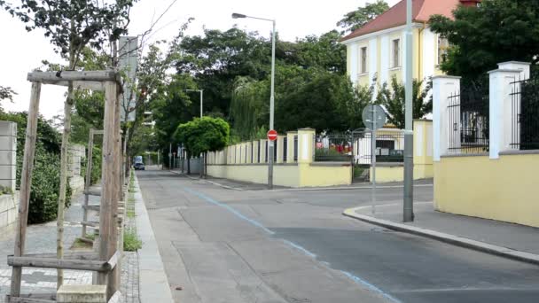 Пустая городская улица - здания с дорогами и природой (деревья) - забор — стоковое видео
