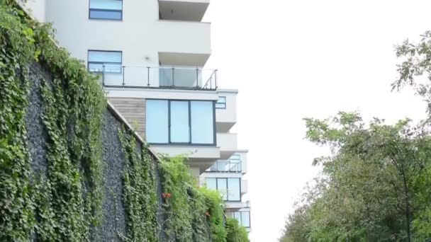 Modernes Gebäude - Balkon - Fenster - Himmel - Zaun mit Natur und Asphaltstraße - — Stockvideo