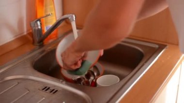 adam gider ve mutfakta bulaşık yıkar