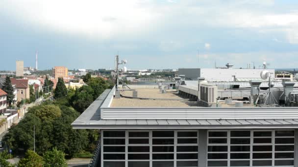 Tetto dell'edificio - aria condizionata e altri dispositivi (sala macchine) - città (edifici sullo sfondo) con la natura - cielo nuvoloso — Video Stock