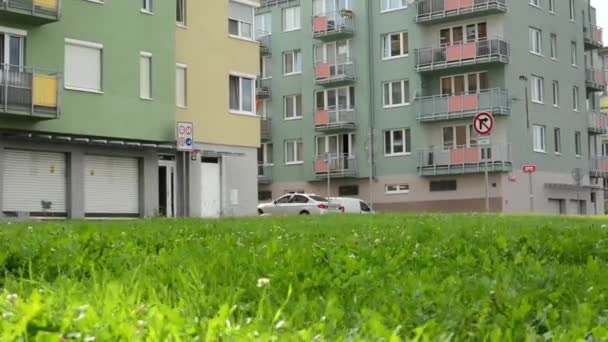 Bloque de gran altura de pisos con hierba verde un coche estacionado - movimiento deslizante — Vídeos de Stock