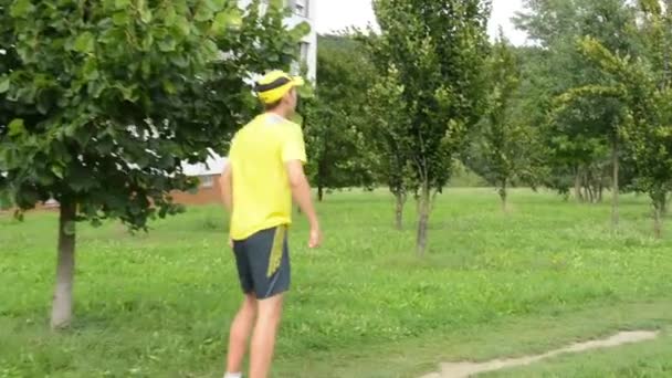 Sports d'homme - course - homme échauffement et puis commencer à courir - herbe verte avec des arbres - steadicam — Video