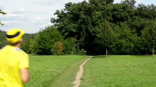 Sports d'homme - course - parc (arbres et herbe) - ciel nuageux - curseur — Video