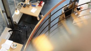 genç kadın merdivenlerden yukarı gidiyor - kişi alt katta oturmak ve konuşmak ve kahve içmek