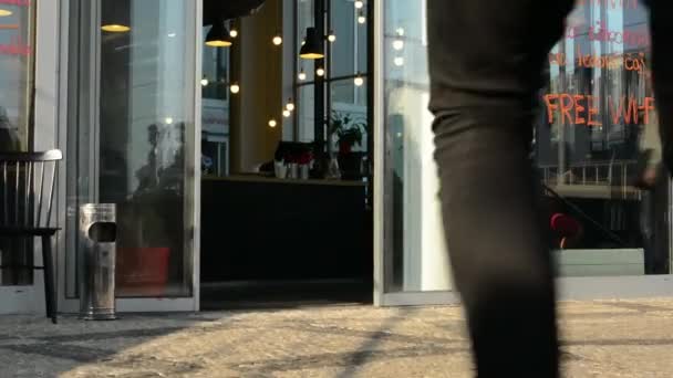 Pareja joven (hombre y mujer) entran en el edificio (café) - reflejo de personas caminando por la ventana — Vídeos de Stock